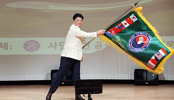 김경태 사) 동아시아 아마추어 골프협회 이사장이 협회기를 흔들고 있다.  